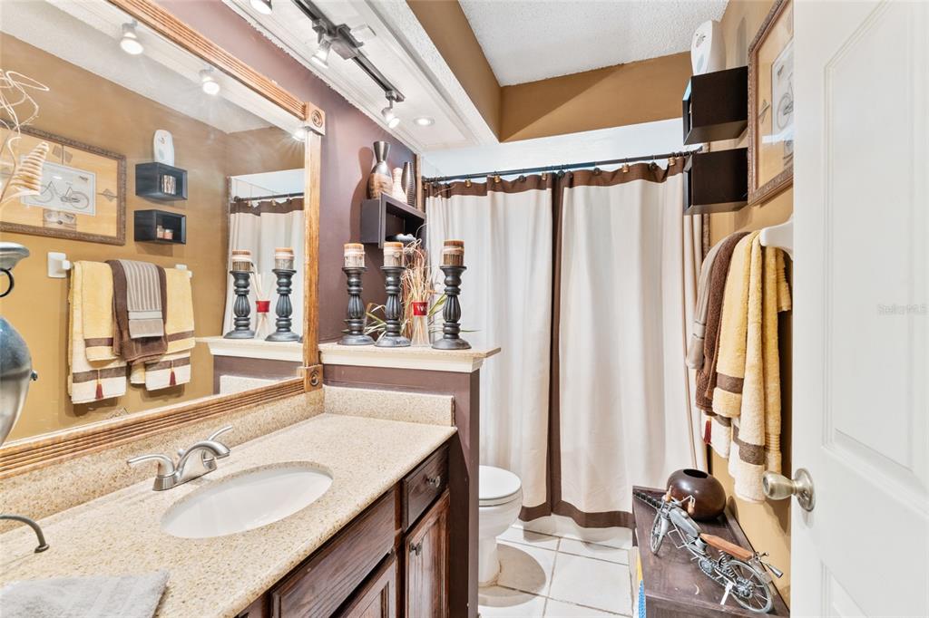 9083 Sable Ridge Court Jacksonville, FL 32244 - Photo 17 of 38 a bathroom with a granite countertop sink a mirror a vanity and a shower