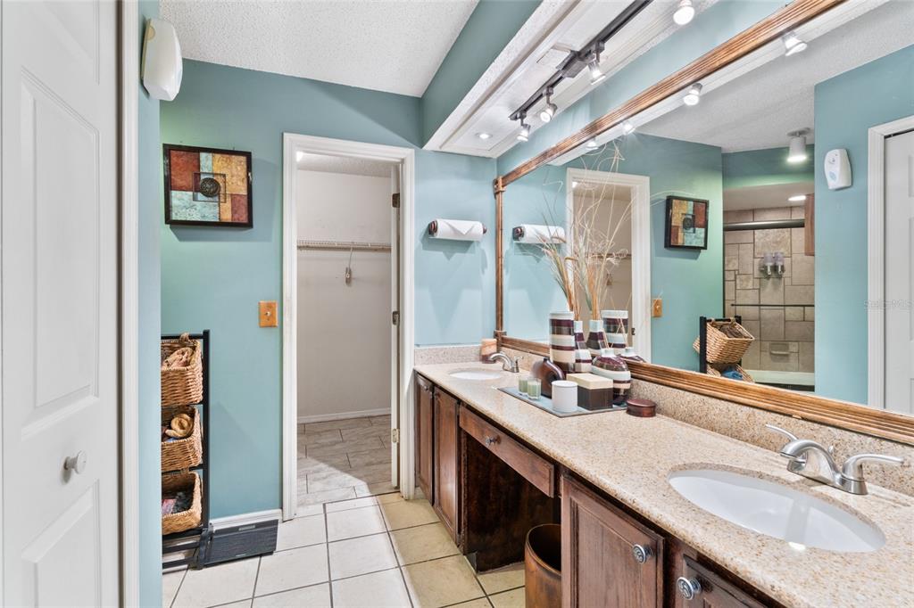9083 Sable Ridge Court Jacksonville, FL 32244 - Photo 24 of 38 a bathroom with a granite countertop double vanity sink a mirror and a shower