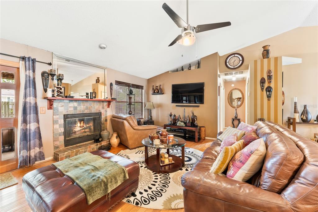 9083 Sable Ridge Court Jacksonville, FL 32244 - Photo 9 of 38 a living room with furniture a fireplace and a flat screen tv