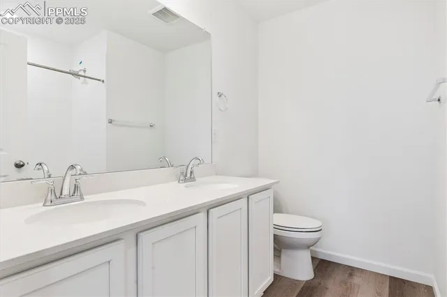 a bathroom with a granite countertop sink a toilet and a mirror