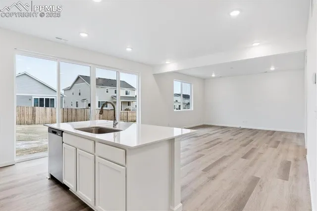 a kitchen with stainless steel appliances granite countertop a sink and dishwasher with white cabinets