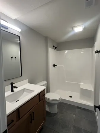 a bathroom with a sink a toilet and shower