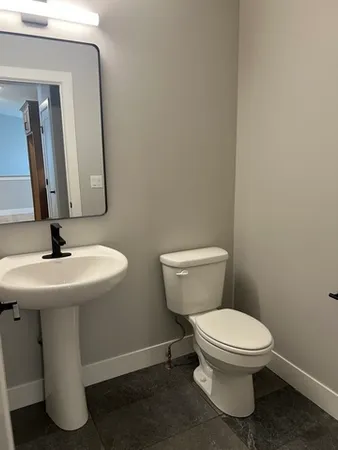 a bathroom with a toilet sink and mirror