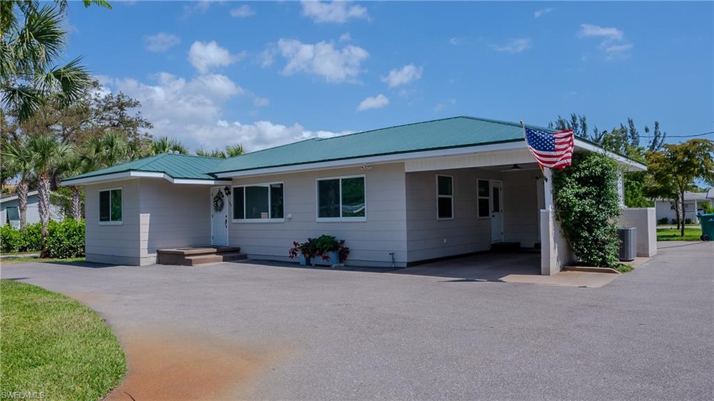 1308 Rosemary Lane Naples, FL 34103 - Photo 14 of 27 a front view of a house with a yard and garage