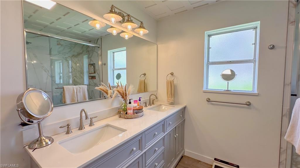 1308 Rosemary Lane Naples, FL 34103 - Photo 6 of 27 a bathroom with a sink vanity and mirror