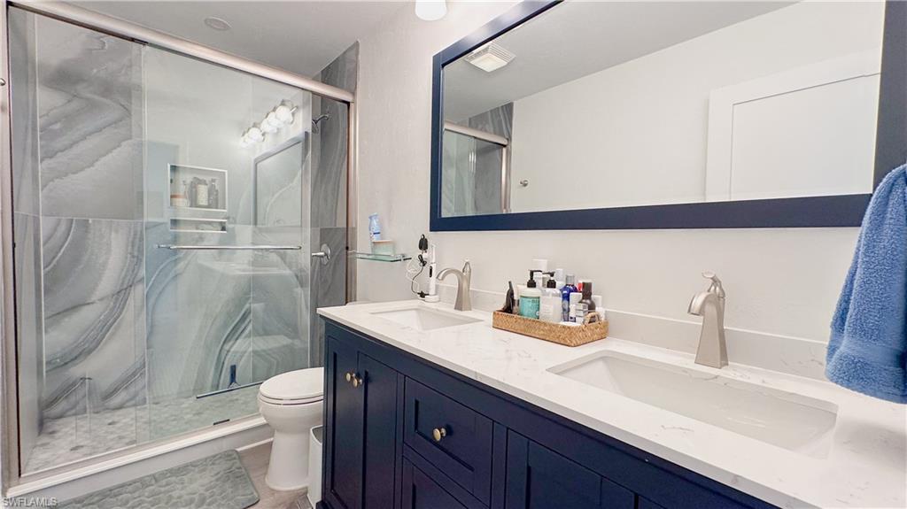 1308 Rosemary Lane Naples, FL 34103 - Photo 9 of 27 a bathroom with a sink vanity granite and toilet