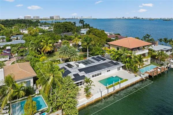 an aerial view of a house with a garden and lake view