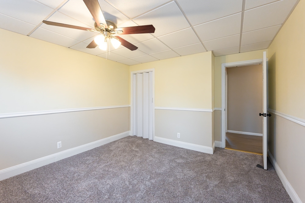 29 Mill Street, Unit B Dracut, MA 01826 - Photo 15 of 37 an empty room with a ceiling fan and carpet