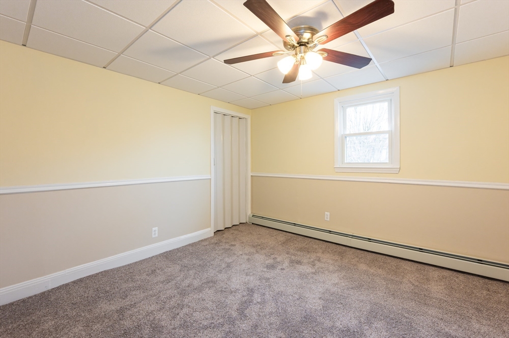 29 Mill Street, Unit B Dracut, MA 01826 - Photo 18 of 37 an empty room with a chandelier fan and windows