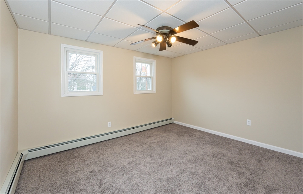 29 Mill Street, Unit B Dracut, MA 01826 - Photo 23 of 37 en empty room with windows and chandelier fan