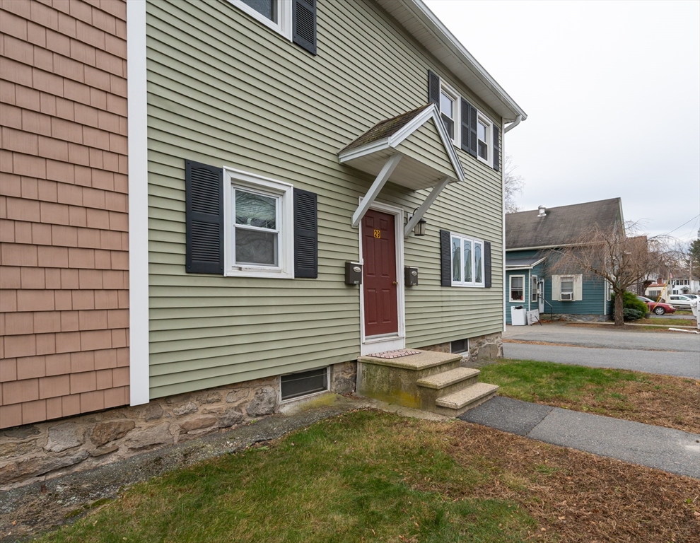 29 Mill Street, Unit B Dracut, MA 01826 - Photo 36 of 37 a view of a house with a yard and garage
