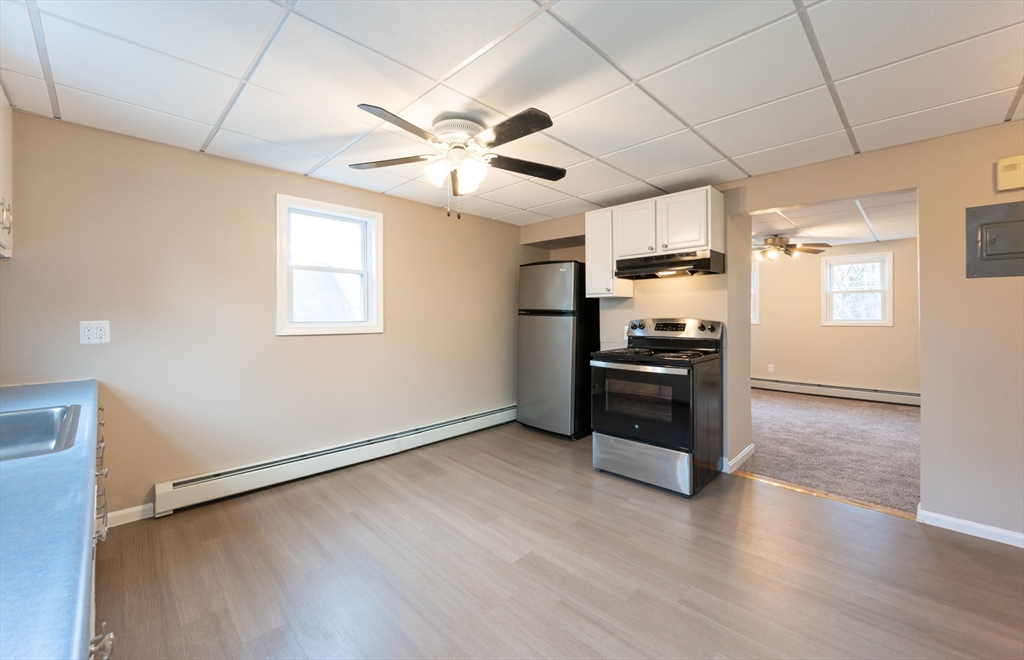 29 Mill Street, Unit B Dracut, MA 01826 - Photo 7 of 37 a view of a kitchen with wooden floor electronic appliances and window
