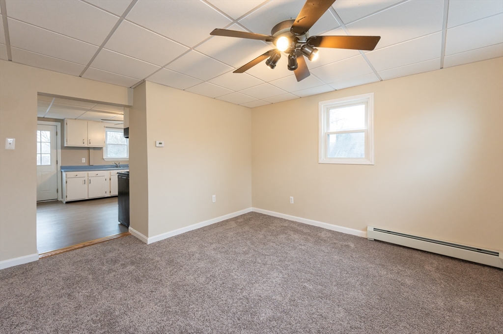 29 Mill Street, Unit B Dracut, MA 01826 - Photo 8 of 37 an empty room with chandelier fan and windows
