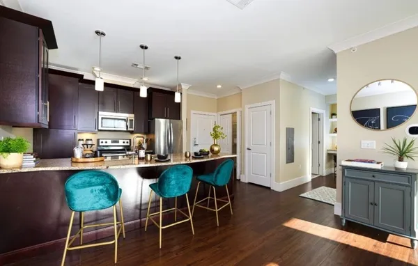 a kitchen with stainless steel appliances a dining table chairs stove and refrigerator