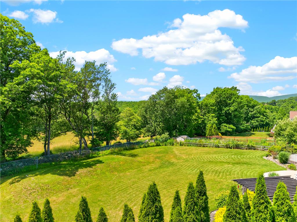 220 Pennbrook Road Stroudsburg, PA 18360 - Photo 54 of 60 Rolling green landscape unfolds, framed by lush trees and distant mountains, under an azure sky.