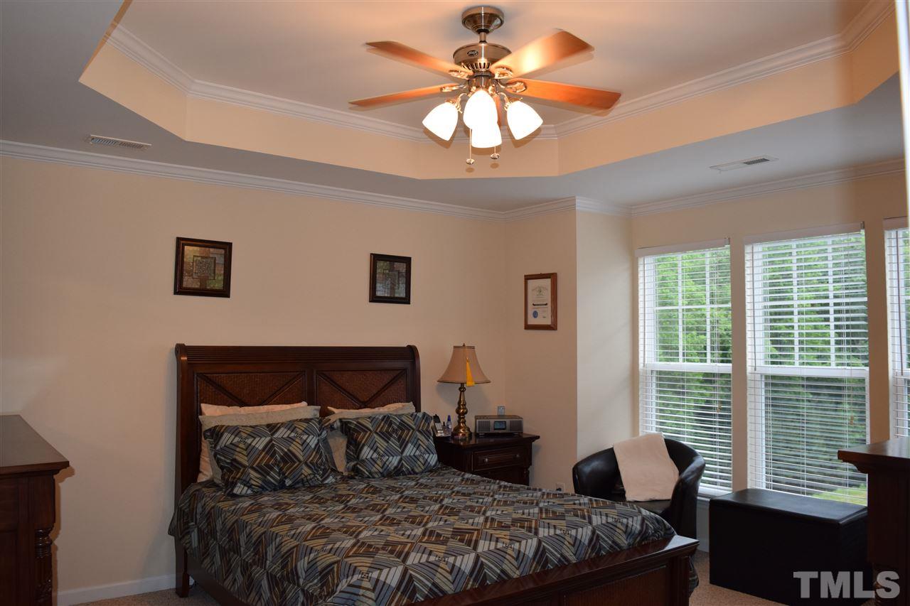 5045 Celtic Court Raleigh, NC 27612 - Photo 18 of 25 a bedroom with a bed and a chandelier