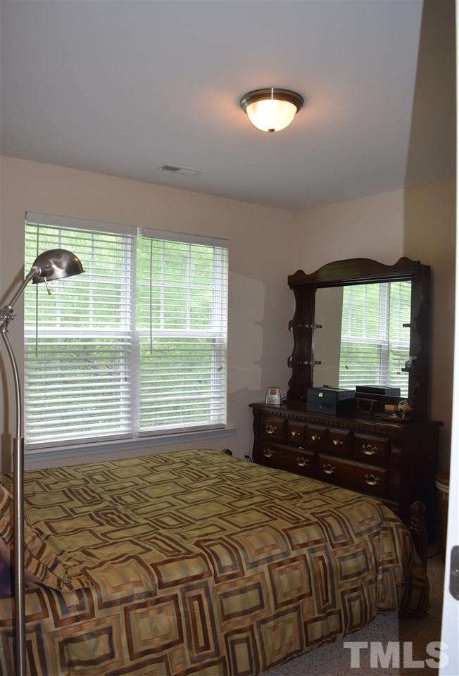 5045 Celtic Court Raleigh, NC 27612 - Photo 20 of 25 a bedroom with a bed and a flat tv screen on dresser