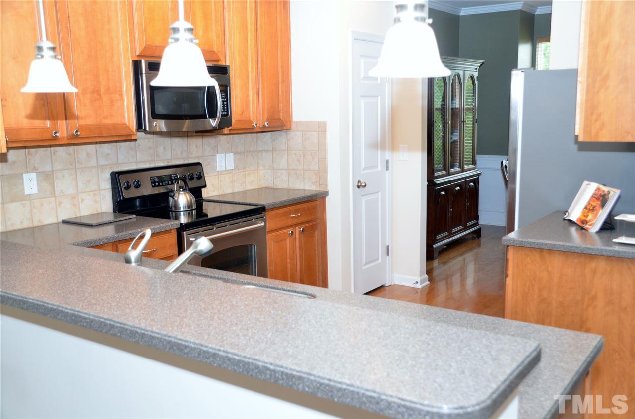 5045 Celtic Court Raleigh, NC 27612 - Photo 5 of 25 a kitchen with stainless steel appliances a stove a refrigerator a sink a stove and a wooden floors