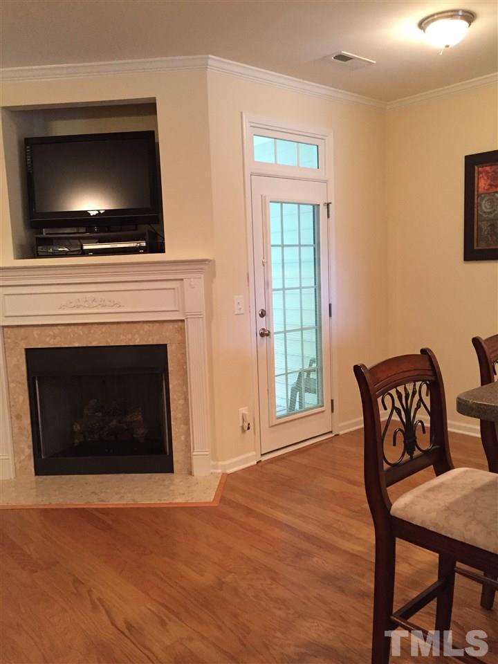 5045 Celtic Court Raleigh, NC 27612 - Photo 10 of 25 a living room with a fireplace a flat screen tv and a fireplace
