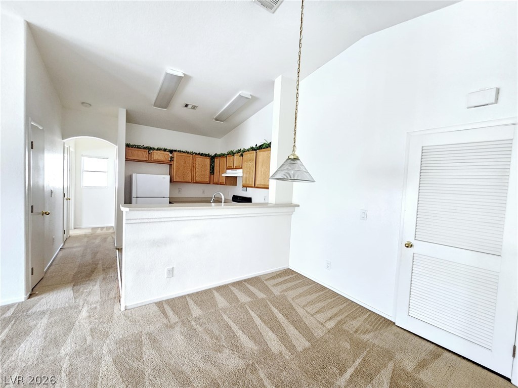 1663 Lefty Garcia Way Henderson, NV 89002 - Photo 31 of 31 An open floorplan connecting living space to a functional kitchen with vaulted ceilings.