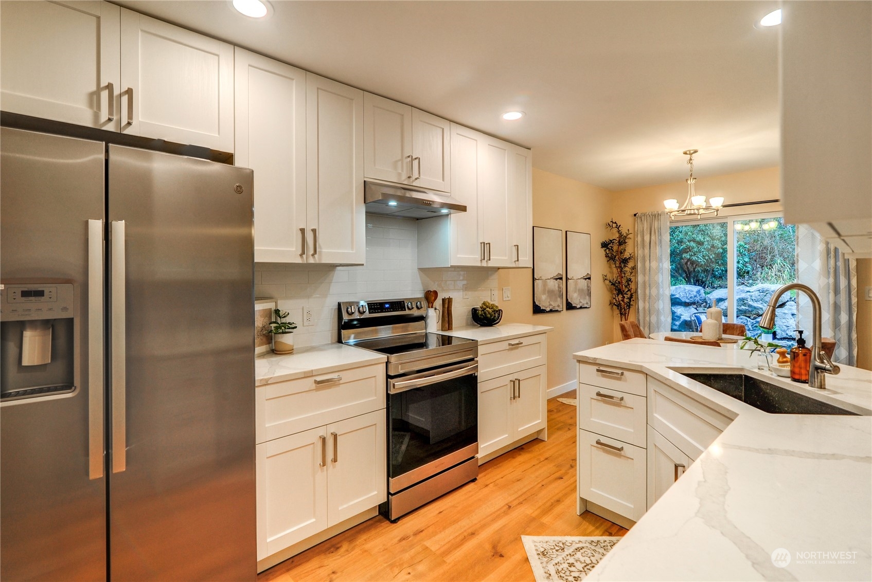 23111 15th Avenue Southeast, Unit E3 Bothell, WA 98021 - Photo 6 of 30 a kitchen with a sink a refrigerator and white cabinets