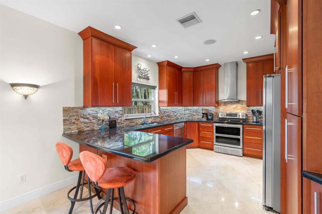 15256 Southwest 108th Terrace Miami, FL 33196 - Photo 13 of 40 a kitchen with stainless steel appliances granite countertop a stove a sink and a refrigerator