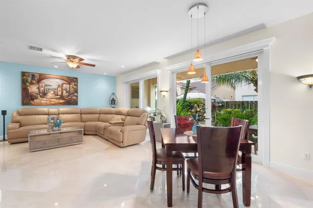 a living room with furniture a chandelier and a dining table