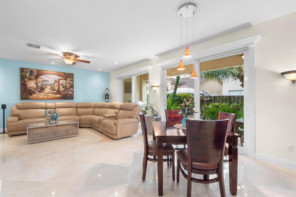 15256 Southwest 108th Terrace Miami, FL 33196 - Photo 15 of 40 a living room with furniture a chandelier and a dining table
