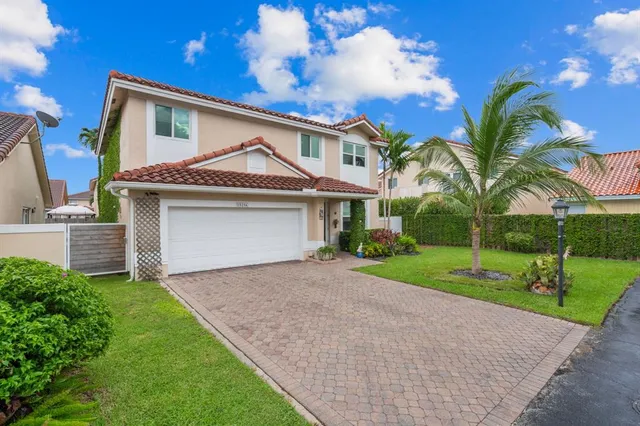 a front view of a house with a yard and garage