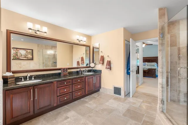 a spacious bathroom with a granite countertop sink and a mirror