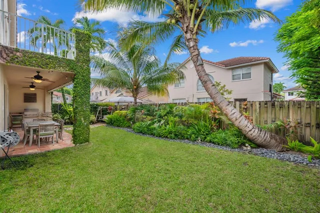 a view of a house with a yard and potted plants