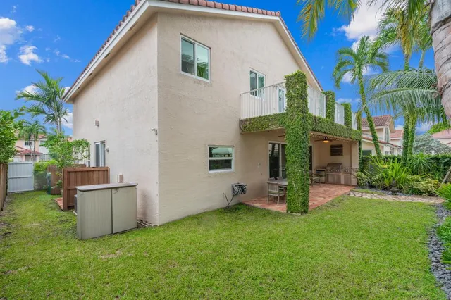 a view of a house with backyard and a tree