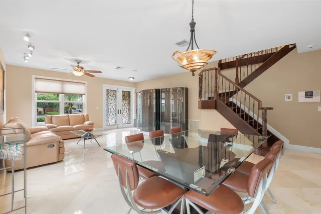 a dining room with furniture a chandelier and wooden floor