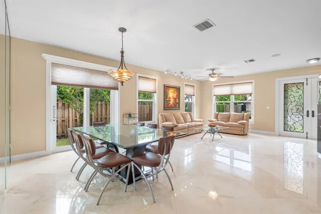 a view of a dining room and livingroom with furniture wooden floor a chandelier