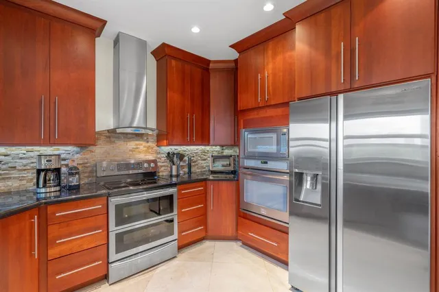 a kitchen with stainless steel appliances granite countertop a refrigerator and a sink
