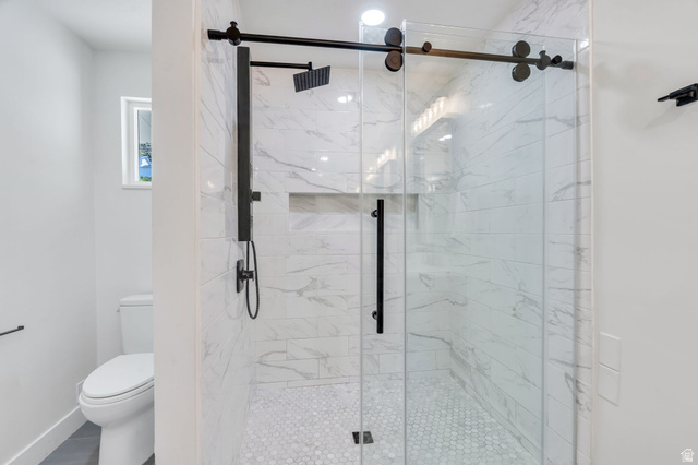 3813 North Foothill Drive Provo, UT 84604 - Photo 41 of 71 Frameless glass shower enclosure with matte black hardware, white subway tile walls with subtle veining, and white hexagonal mosaic floor tiles