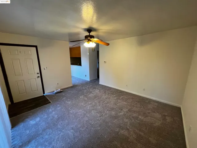 an empty room with closet and a chandelier fan