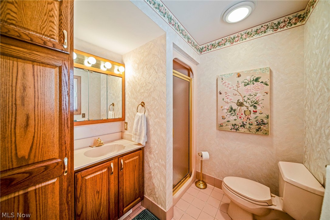 8801 Bunker Road Orwell, OH 44076 - Photo 38 of 50 Bathroom featuring light tile patterned floors, vanity, a stall shower, and wallpapered walls