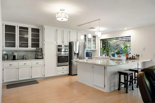 a kitchen with stainless steel appliances a sink stove and refrigerator