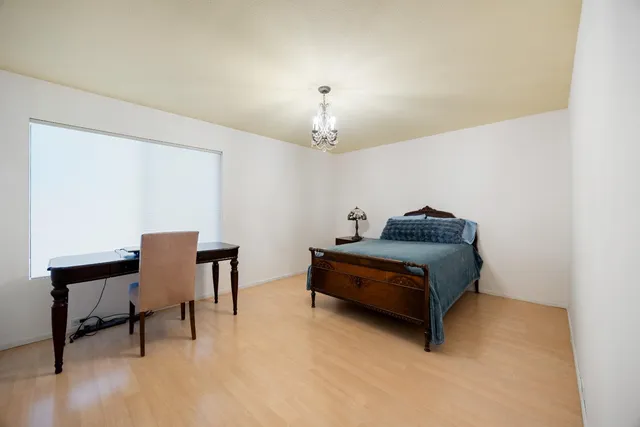 a bedroom with furniture and a chandelier fan
