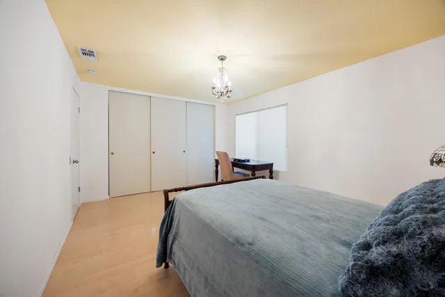 a bedroom with a bed and a chandelier