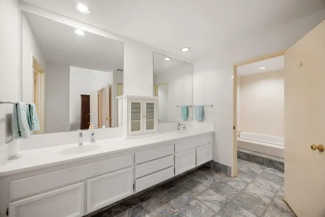 a bathroom with 2 sink tub and a mirror