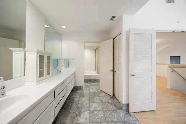 a bathroom with a double vanity sink and mirror