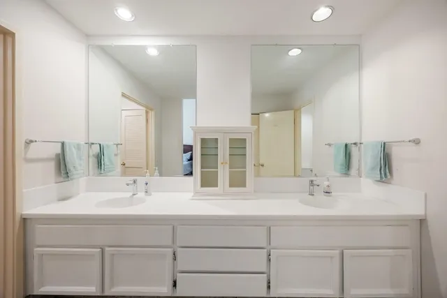 a bathroom with double sink and a mirror