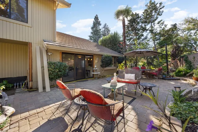 a view of a patio with table and chairs potted plants and palm tree