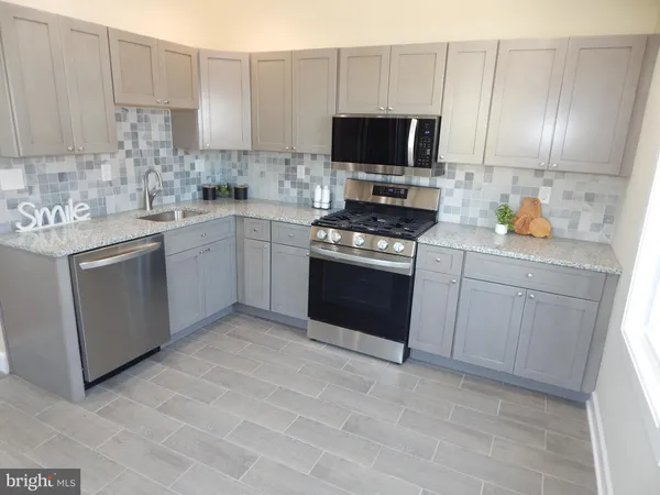 a kitchen with stainless steel appliances granite countertop a stove top oven a sink dishwasher and a refrigerator