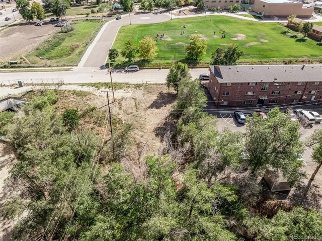 an aerial view of a house with a yard and large trees