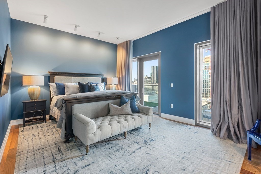 300 Pier 4 Blvd., Unit PHC Boston, MA 02210 - Photo 18 of 42 a spacious bedroom with a bed and lamp