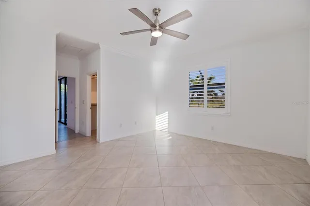 an empty room with closet and a ceiling fan