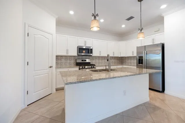 a large kitchen with kitchen island a sink stainless steel appliances and cabinets